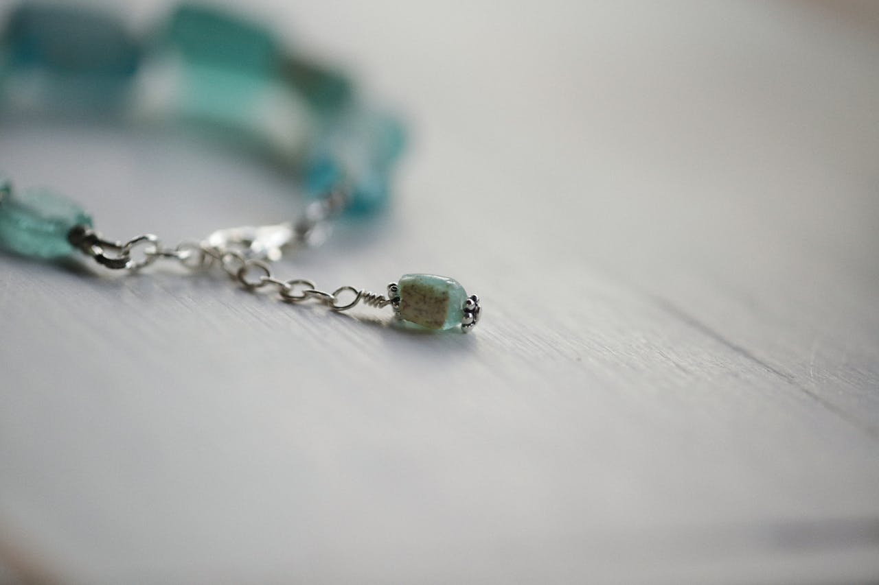 about-us-01 Close-up of a delicate gemstone bracelet with soft focus effect.